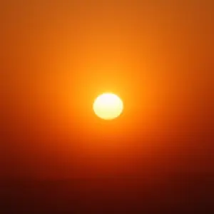 Porque O Sol É Amarelo Para Nós Dispersão Atmosférica E A Cor Aparente Sol dourado brilhando através do céu enevoado ao pôr do sol, mostrando a dispersão atmosférica.