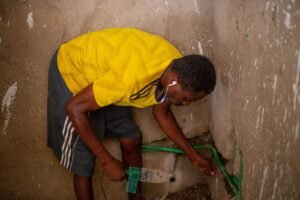Plumber working on a water connection in an apartment.