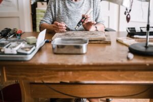 Woman make jewelry with professional equipment at home