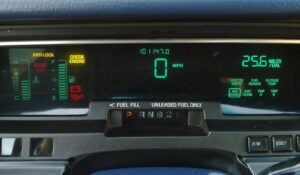 Digital dashboard cluster of a Mercury Grand Marquis. The cluster features three VFD displays (left third, middle third and right third). Varying colo